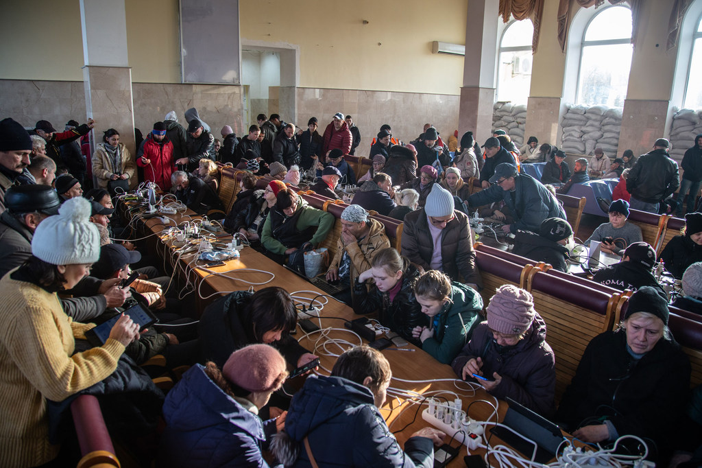 Des civils qui ont fui leurs maisons en Ukraine à cause de la guerre rechargent leurs téléphones portables et utilisent le wifi à la gare de Kherson (photo d'archives).