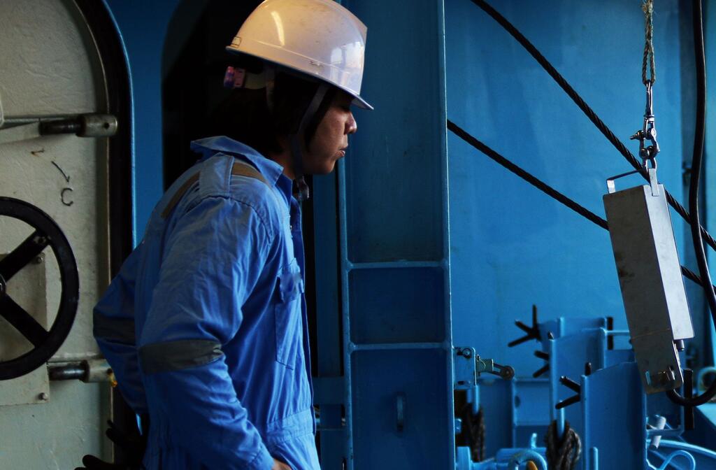 A seafarer works on a ship.
