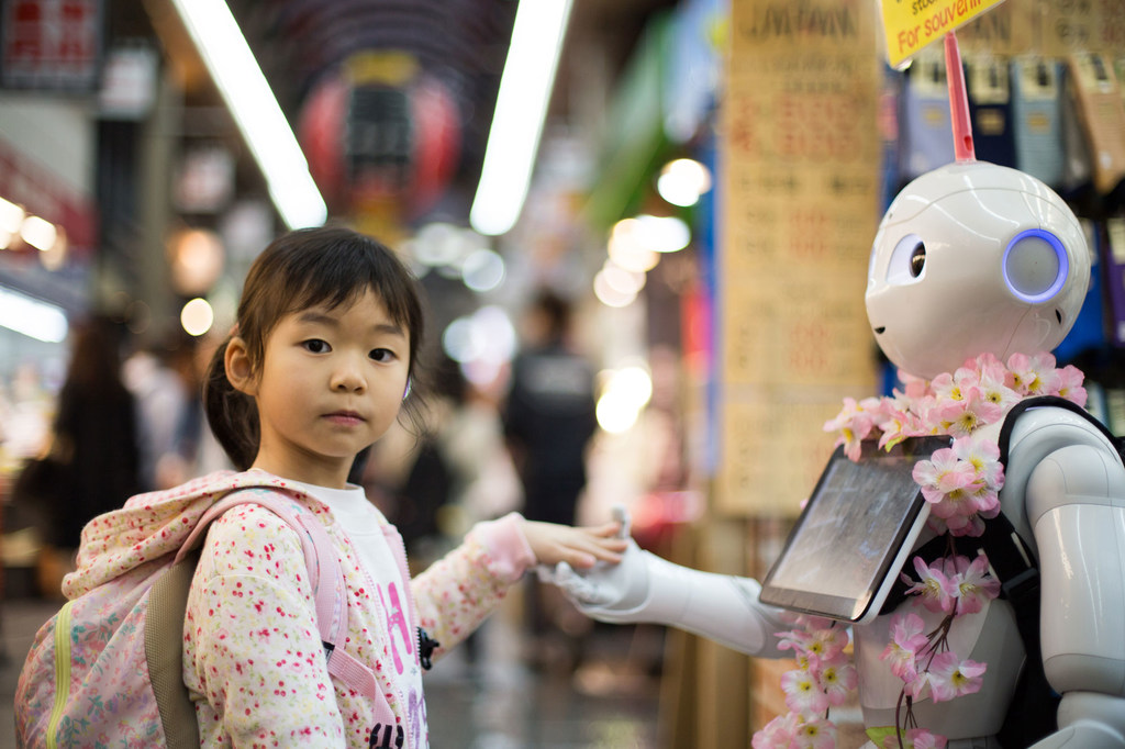 Una niña interactúa con un robot en Osaka, Japón.