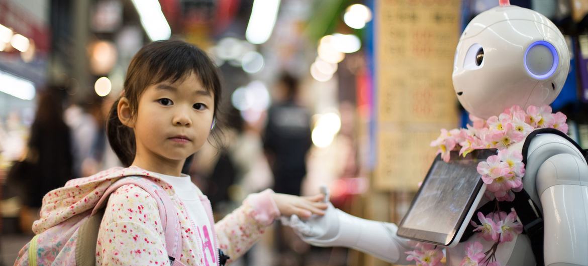 在日本大阪，一个小女孩在与机器人互动。