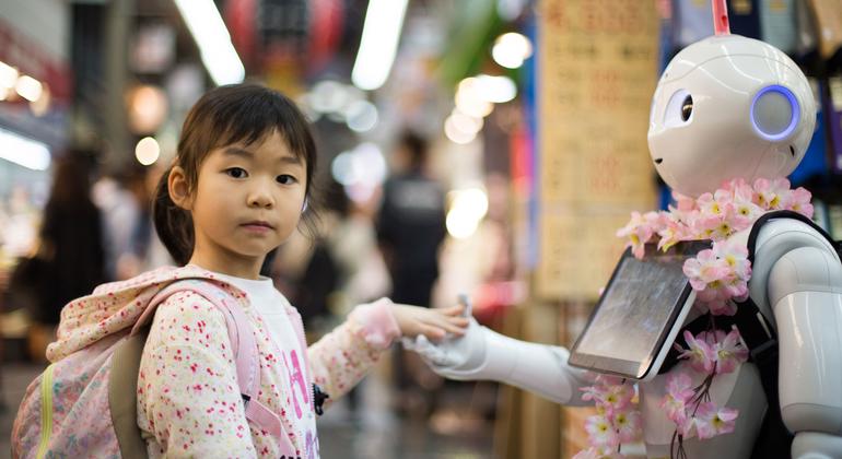 A girl interacts with a robot in Osaka, Japan.
