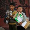 طفلان في غزة يجمعان الورق المقوى لإشعال النيران لأغراض الطهي.