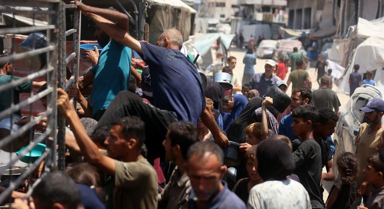 Des hommes à la recherche de nourriture escaladent les barrières d'une cuisine communautaire dans l'ouest de Gaza-ville.