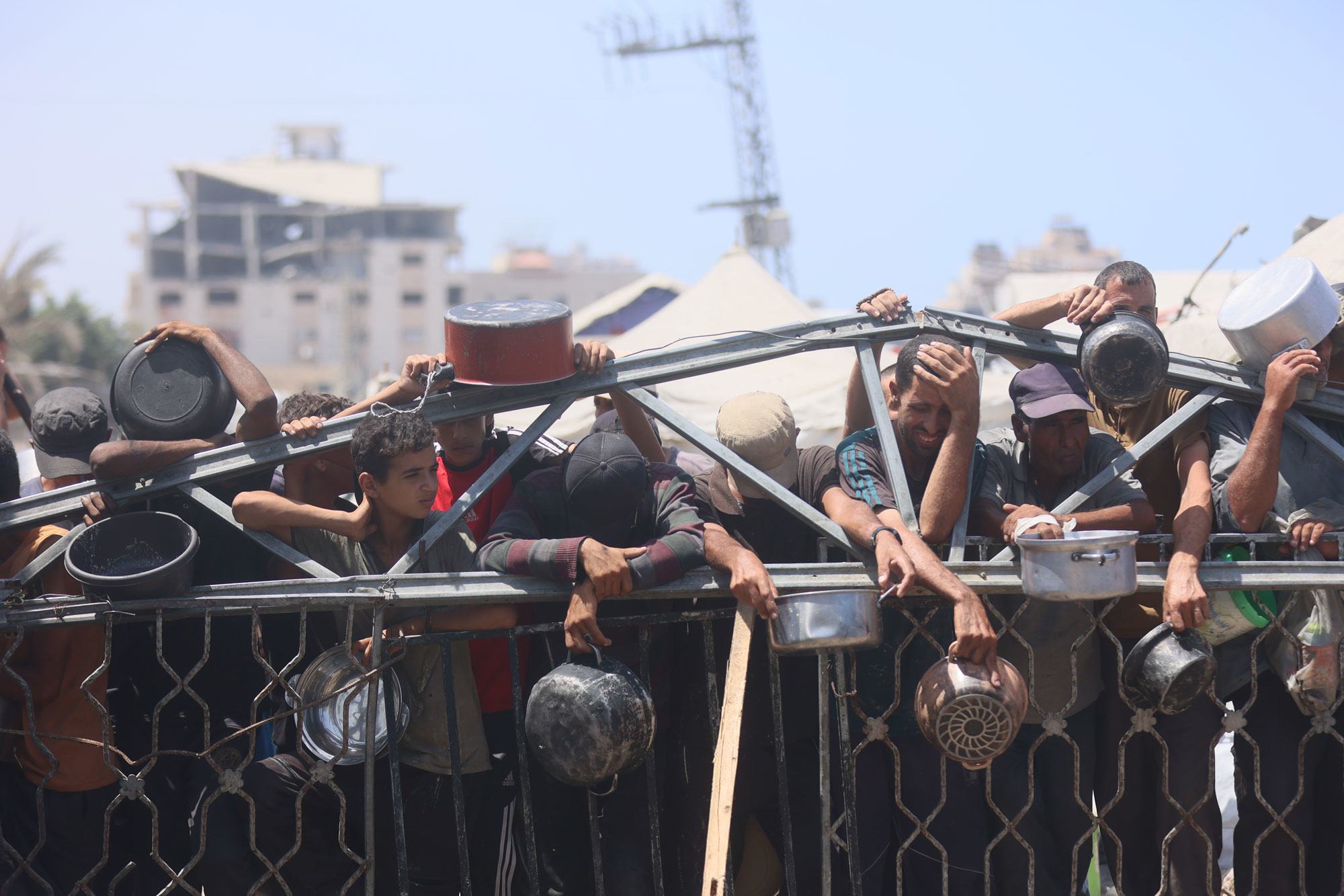 Des Palestiniens attendent de la nourriture près d'une cuisine communautaire, dans l'ouest de la ville de Gaza.