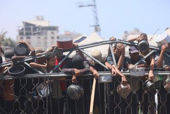 People wait for food at a community kitchen in western Gaza City.