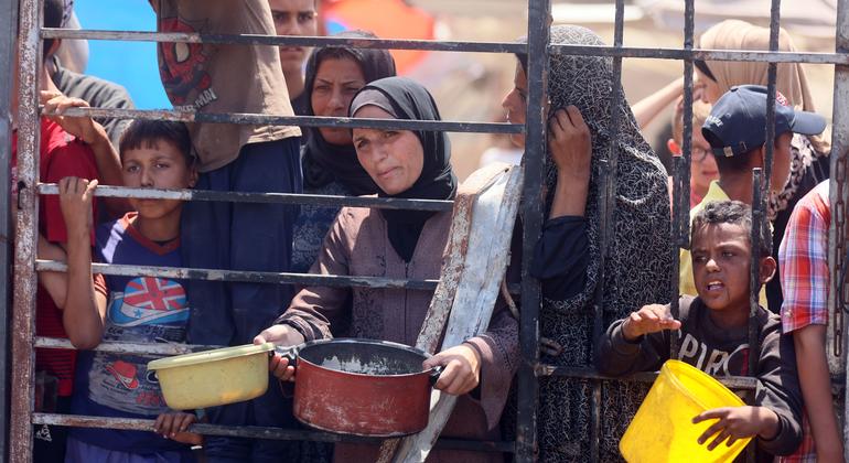 Des femmes et des enfants attendent de la nourriture dans une cuisine communautaire à l'ouest de la ville de Gaza.