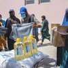 Personal humanitario de la ONU entrega alimentos y mantas a la gente necesitada en Kabul, Afganistán. 