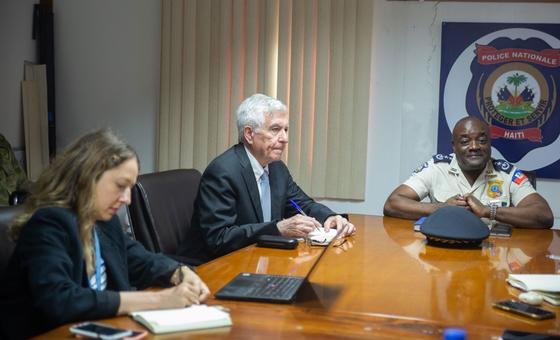 William O'Neill meets with a National Police officer at a table in Port-au-Prince.