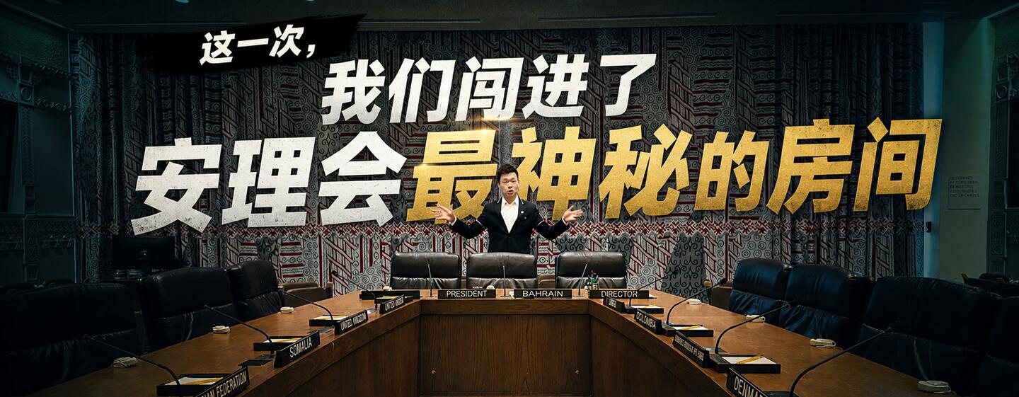 一名身着西装的男子站在联合国安理会会议室内的一张大型会议桌旁，桌上可见各国名称牌。