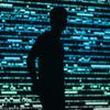 Силуэт мужчины, стоящего перед синим цифровым экраном с данными.
