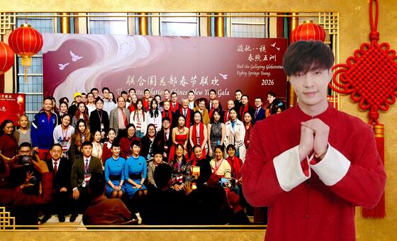 一个穿着传统红色中国服装的男子站在2026年联合国春节嘉年华的群组照片前, 周围有红灯和中国等节日装饰.