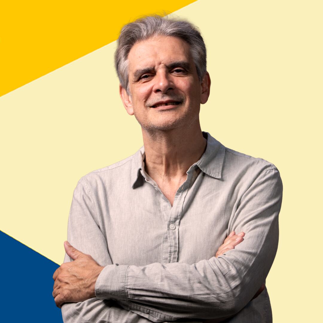 Miniatura del podcast que muestra a un hombre de pelo gris con una camisa gris claro y los brazos cruzados sobre un fondo geométrico diagonal amarillo y azul.