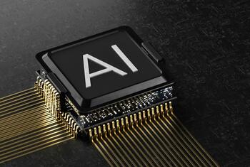 A close-up of a computer chip with 'AI' printed on its surface, connected by gold pins on a dark circuit board.