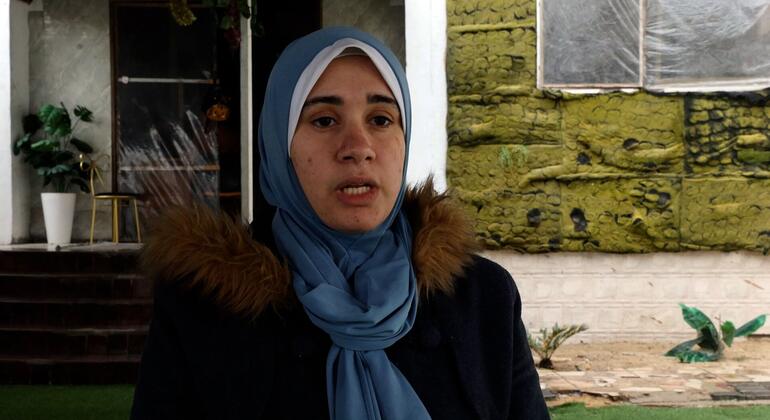 صورة لفتاة فلسطينية ترتدي حجاب أزرق مع معطف داكن مع طوق من الفراء، وتتحدث خلال مقابلة بمناسبة يوم الوعي بالتوحد في غزة.