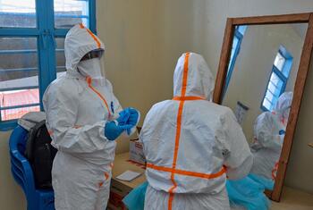 Des travailleurs de la santé en tenue de protection se préparent au traitement de l'Ebola à Bunia, en RDC.