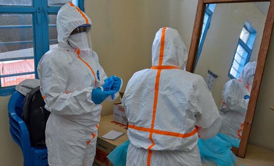 Healthcare workers in protective gear prepare for Ebola treatment in Bunia, DRC.