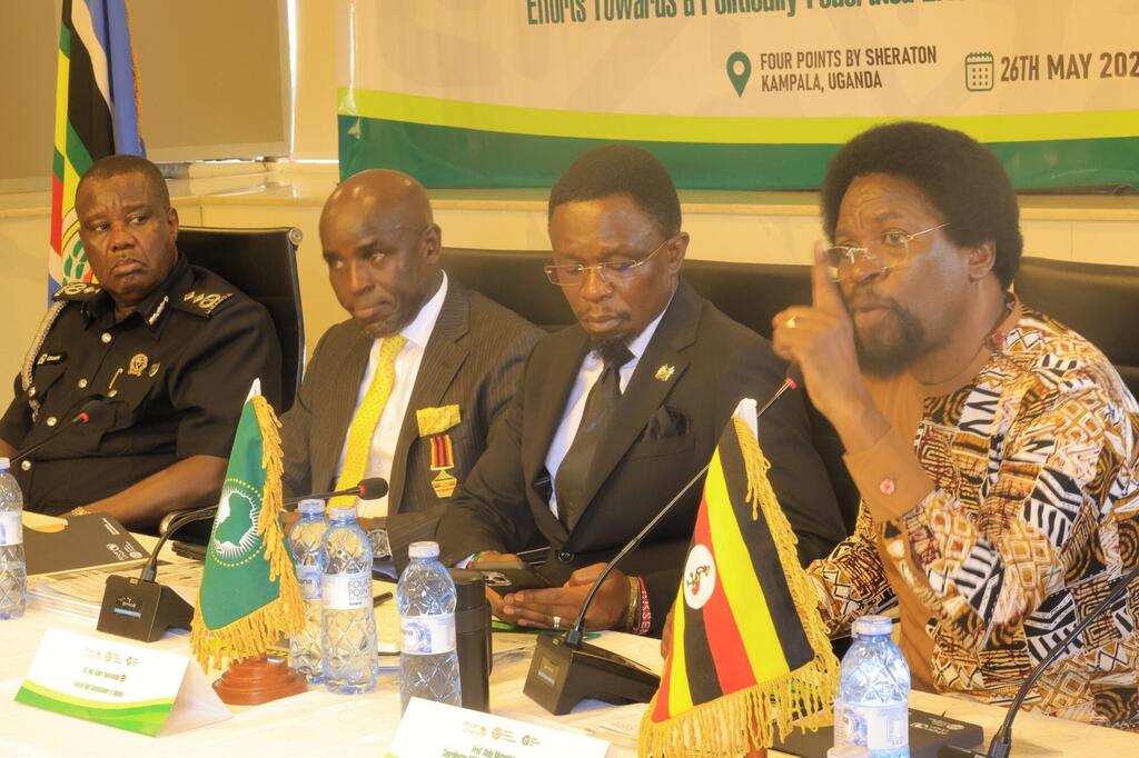 Wanaume wanne wa Afrika wenye mavazi rasmi wamekulia kwenye meza ya mkutano wakati wa mazungumzo ya jopo katika tukio moja huko Kampala, Uganda.