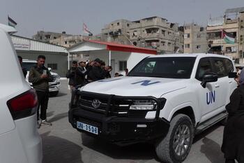 A UN vehicle prepares to transport patients from Al-Amal Hospital in Rafah, Gaza, affiliated with the Palestinian Red Crescent Society, as people gather around.
