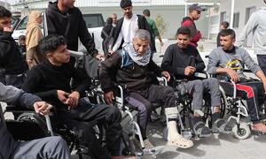 Los pacientes, incluidos algunos en sillas de ruedas, están siendo preparados para el transporte en el Hospital Al-Amal en Gaza, afiliado a la Sociedad Palestina de la Media Luna Roja.