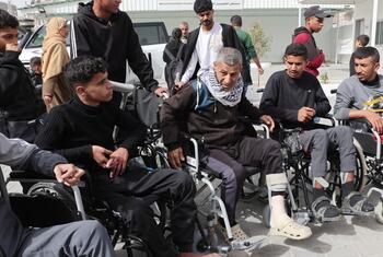 Los pacientes, incluidos algunos en sillas de ruedas, están siendo preparados para el transporte en el Hospital Al-Amal en Gaza, afiliado a la Sociedad Palestina de la Media Luna Roja.