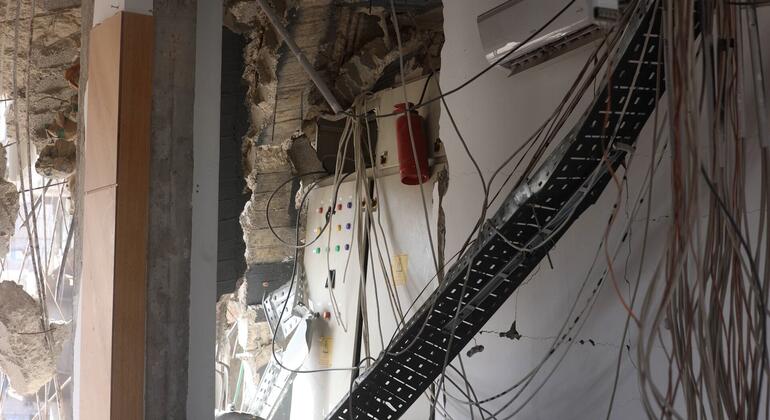 مبنى مدمر مع تشغيل الكابلات المكشوفة والحطام، مما يشير إلى التدمير في غزة، كما ذكرت إذاعة الأمم المتحدة نيوز زامان.