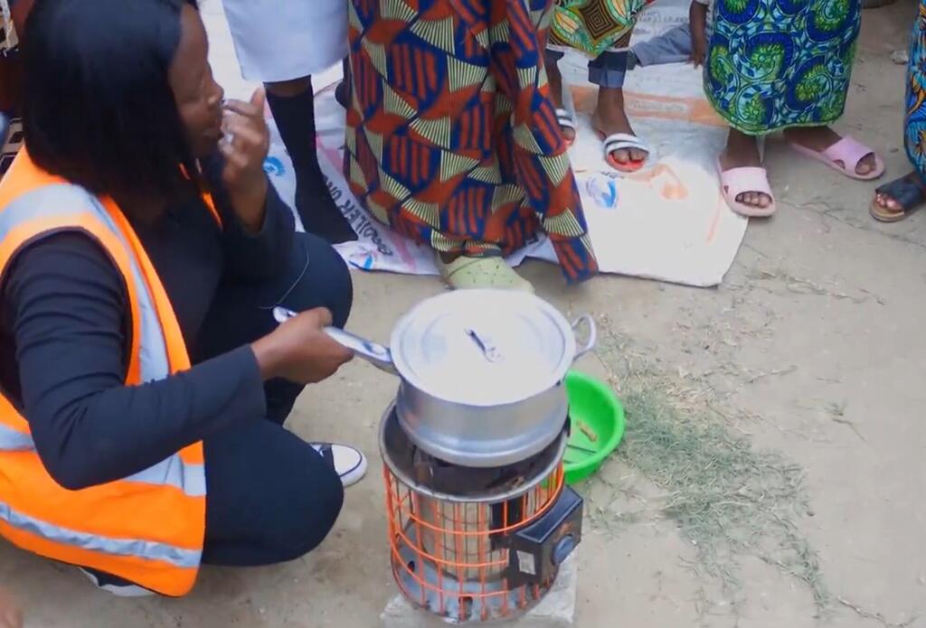 Mfanyakazi wa kujitolea wa UNICEF nchini Zambia huandaa chakula kwa kutumia jiko linaloweza kubebwa kwa ajili ya programu ya lishe ya watoto.