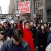 Uma multidão de manifestantes marcha na cidade de Nova York durante a Marcha das Mulheres de 2017, segurando cartazes defendendo os direitos das mulheres e a igualdade de gênero.