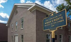 Alama ya kihistoria yenye maandishi 'Mkutano wa Kwanza wa Haki za Wanawake ulifanyika katika kona hii 1848' imesimama mbele ya jengo la matofali huko New York.