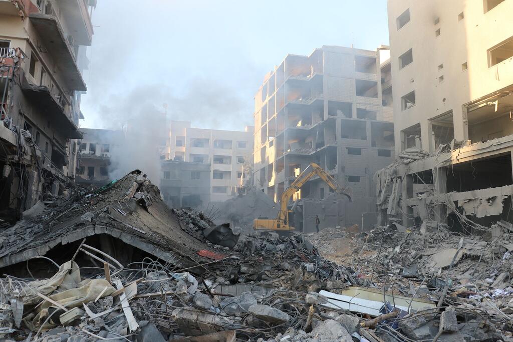 Un excavateur opère parmi des bâtiments endommagés et des débris dans un quartier résidentiel de Tyr, au Liban, à la suite d'une frappe aérienne.