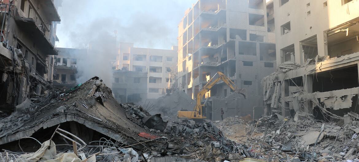 Un excavateur opère parmi des bâtiments endommagés et des débris dans un quartier résidentiel de Tyr, au Liban, à la suite d'une frappe aérienne.