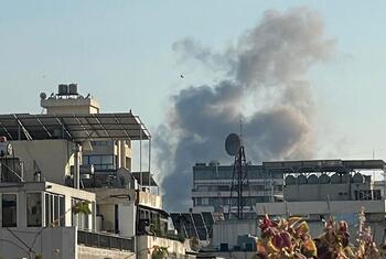 A large plume of smoke rises over the urban skyline of Beirut, Lebanon, near UNIFIL positions, indicating an explosion or ongoing conflict.