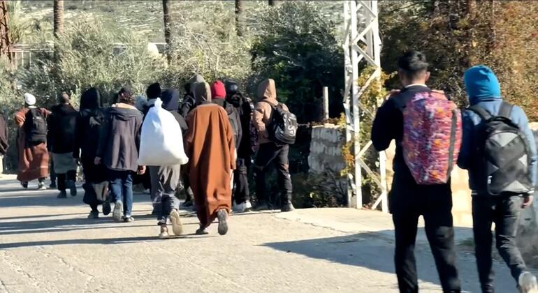 Люди, спасающиеся от эскалации ливанско-израильской границы в Ливане, ходят пешком, неся личные вещи.