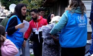 UNHCR staff distribute emergency relief items to displaced people in Beirut, Lebanon, as families gather to receive support kits following recent displacement.
