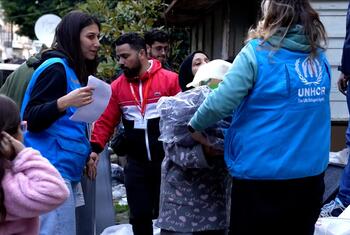 Des personnes déplacées à Beyrouth, au Liban, se rassemblent pour recevoir des kits de soutien des travailleurs du HCR qui distribuent de l'aide.
