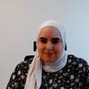 A woman wearing a white hijab and a floral top, identified as Assadi, a panelist at a UN News event on Artificial Intelligence.