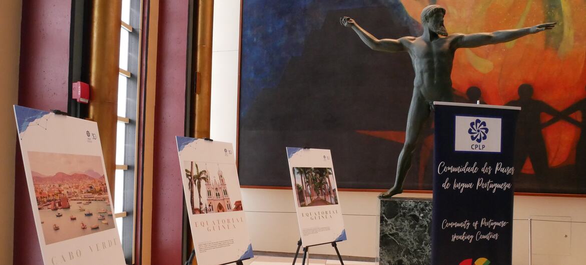 Placas de exposição da Comunidade dos Países de Língua Portuguesa (CPLP) num evento, com informações sobre Cabo Verde e Guiné Equatorial.