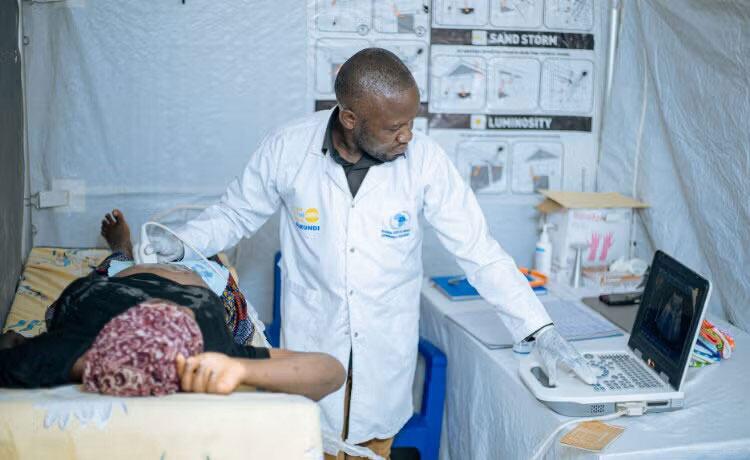 Mwanamume mtaalamu wa uzazi anafanya ukaguzi wa sauti ya juu (ultrasound) kwa mwanamke mjamzito katika kliniki iliyopo kwenye kambi ya wakimbizi ya Musenyi nchini Burundi.