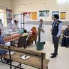 Un funcionario de la OMS habla con una doctora y pacientes dentro de un centro de salud en la India.