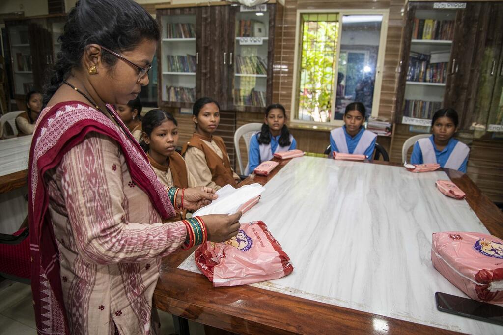 कंधमाल के दुतिपाड़ा सरकारी हाई स्कूल में एक शिक्षिका छात्राओं को सैनिटरी पैड के उपयोग के बारे में समझाते हुए और निःशुल्क सैनिटरी नैपकिन वितरित करती हुई.