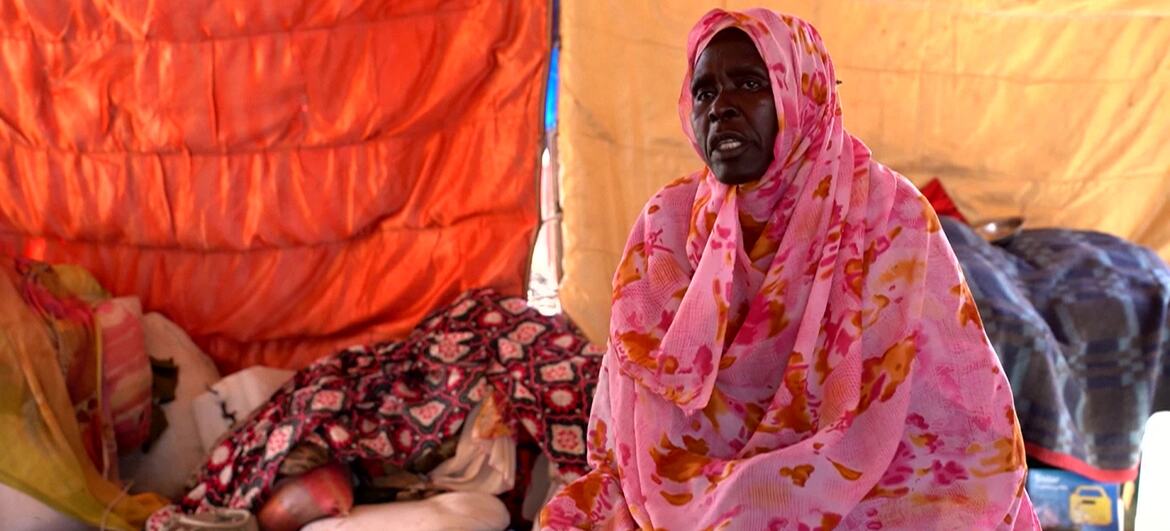 سيدة ترتدي ثوبا سودانيا وردي اللون تجلس داخل خيمة في مخيم للنازحين في القضارف - السودان