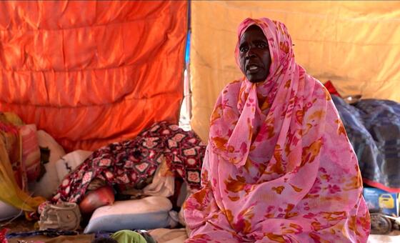 A woman in a pink patterned Sudanese Thob (Dress) sits inside a tent at Abu Al Naja camp in Sudan, highlighting the humanitarian crisis affecting displaced populations.
