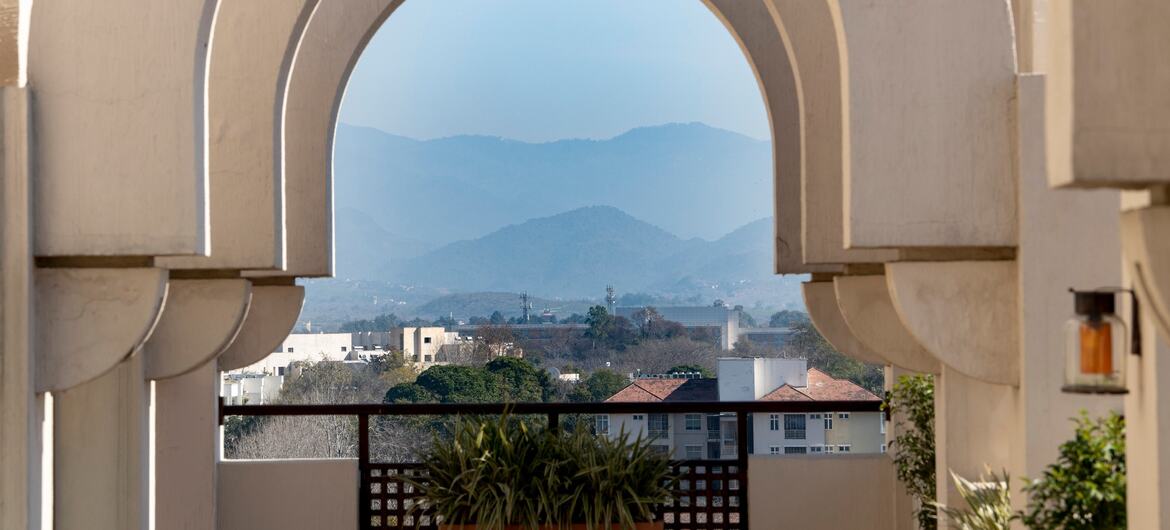 A view of Islamabad, Pakistan, showcasing a series of arches framing a distant mountain range and urban landscape.