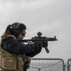 Helena, marinheira da Marinha Portuguesa, aponta uma arma portátil durante um exercício de treino no navio NRP Corte Real no Mar Báltico.
