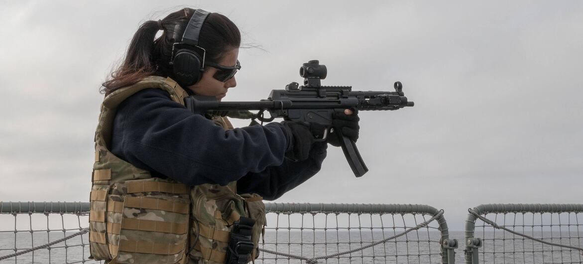 Helena, marinheira da Marinha Portuguesa, aponta uma arma portátil durante um exercício de treino no navio NRP Corte Real no Mar Báltico.