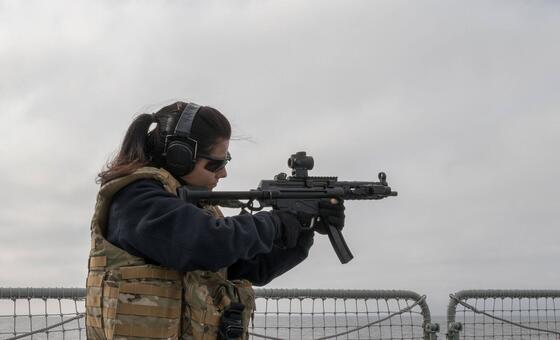 Helena, marinheira da Marinha Portuguesa, aponta uma arma portátil durante um exercício de treino no navio NRP Corte Real no Mar Báltico.