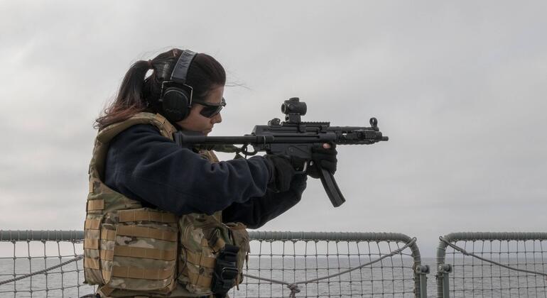 Helena, marinheira da Marinha Portuguesa, aponta uma arma portátil durante um exercício de treino no navio NRP Corte Real no Mar Báltico.