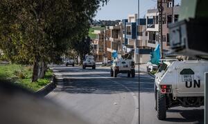 Un convoy de vehículos blindados blancos de la UNIFIL conduce a lo largo de una carretera en el Líbano, con banderas de la ONU visibles. La imagen muestra a las fuerzas de paz francesas y finlandesas que participan en la operación DAMAN 54.