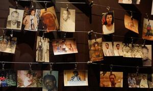 A memorial display of photographs of victims of the 1994 genocide against the Tutsi in Rwanda, hanging from wires.