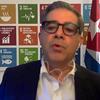 Francisco Pichon, Coordinador Residente en Cuba, informa a los periodistas sobre la situación en el país, de pie frente a un cartel de los Objetivos de Desarrollo Sostenible de la ONU y las banderas de Cuba y de la ONU.