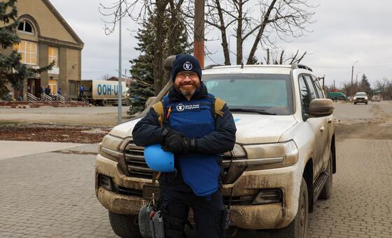 Oleg Kemin from the UN World Food Programme (WFP) stands in front of his vehicle in Kherson, Ukraine.